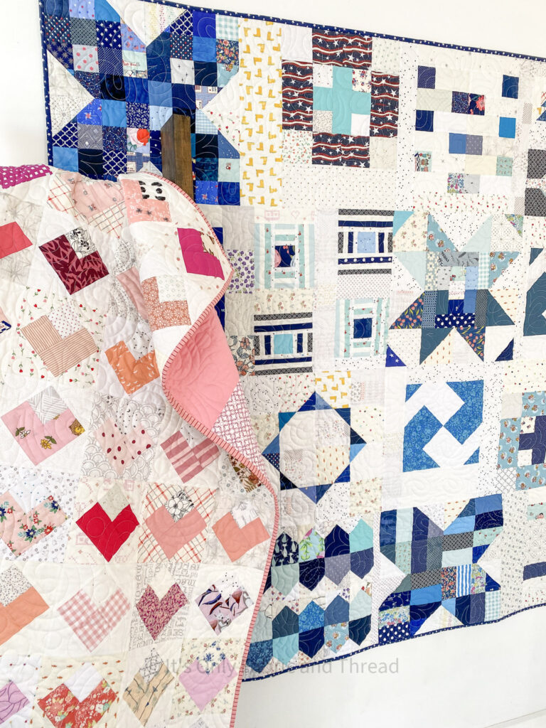 Blue and White Fun With Scraps Quilt and Pink and White All My Hearts Quilt are displayed on the wall and a blanket ladder