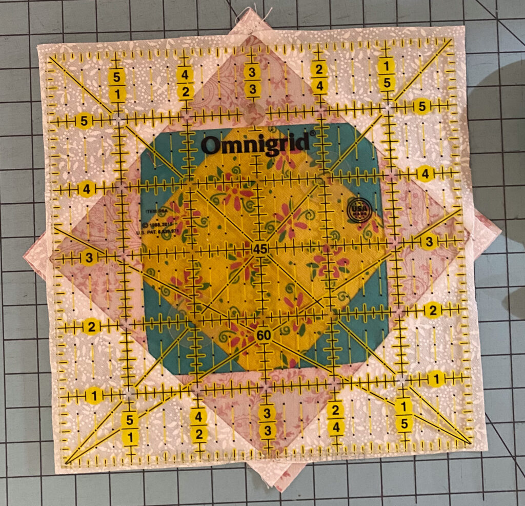 Scrap Explosion Quilt Block with a 6" ruler set on top of the block.